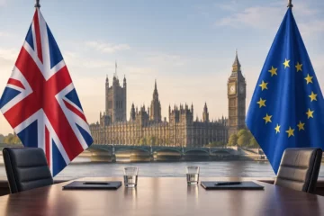 Koncepcyjna ilustracja redakcyjna: sylwetka Pałacu Westminsterskiego oraz flagi Wielkiej Brytanii i Unii Europejskiej, symbolizujące dialog i negocjacje.